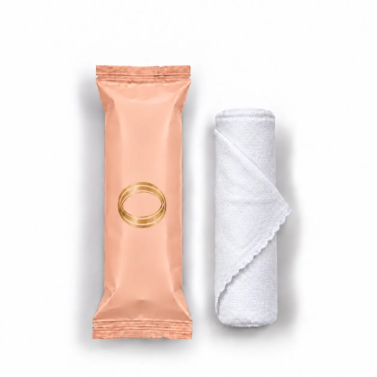 Orange Blossom oshibori towel in peach packaging beside the rolled white microfiber towel