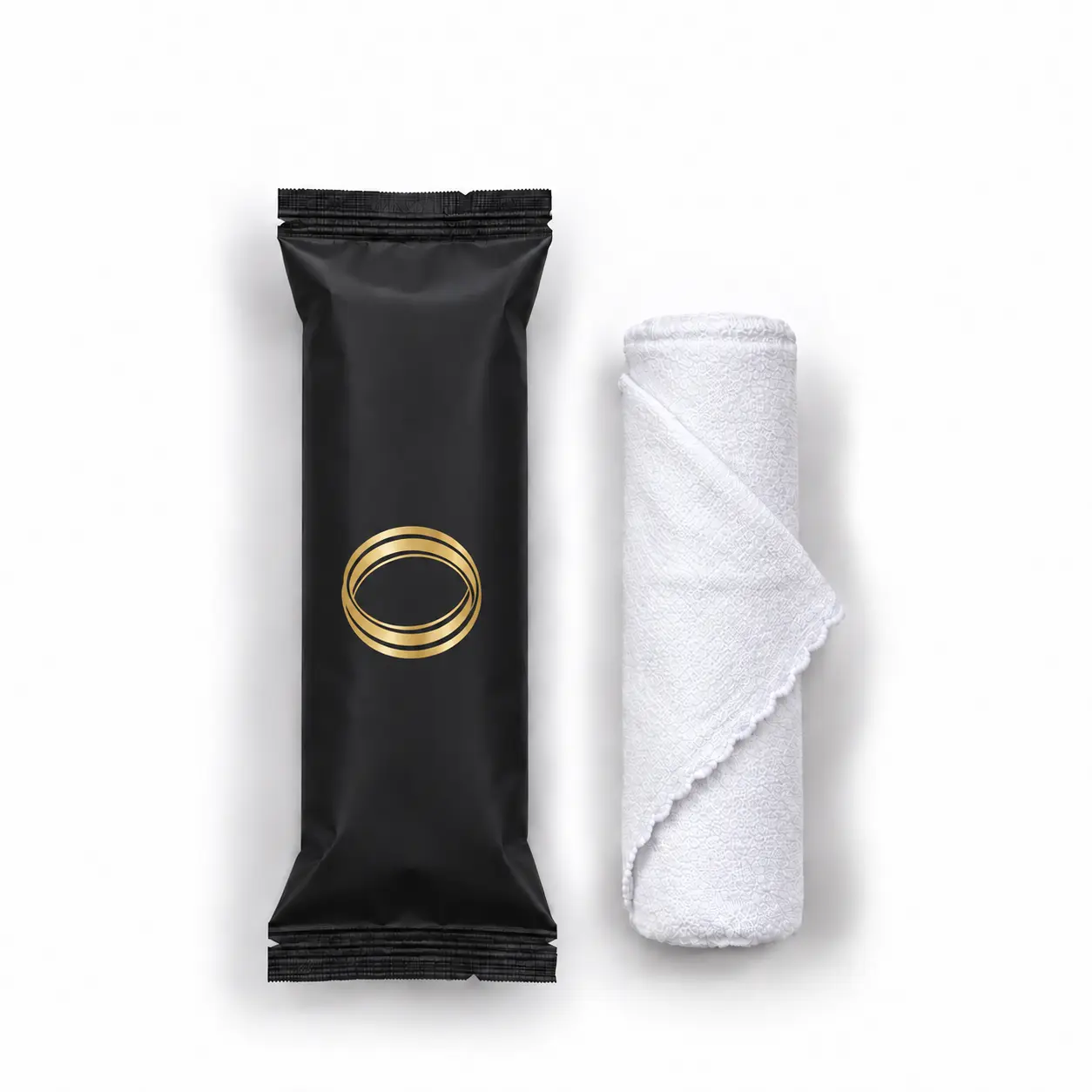 Green Tea oshibori towel in matte black packaging, shown upright beside the rolled white microfiber towel